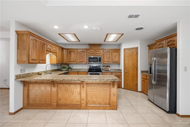 kitchen featuring a peninsula, visible vents, stainless steel appliances, and a sink