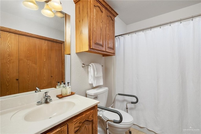 bathroom featuring toilet, a textured wall, a shower with shower curtain, and vanity