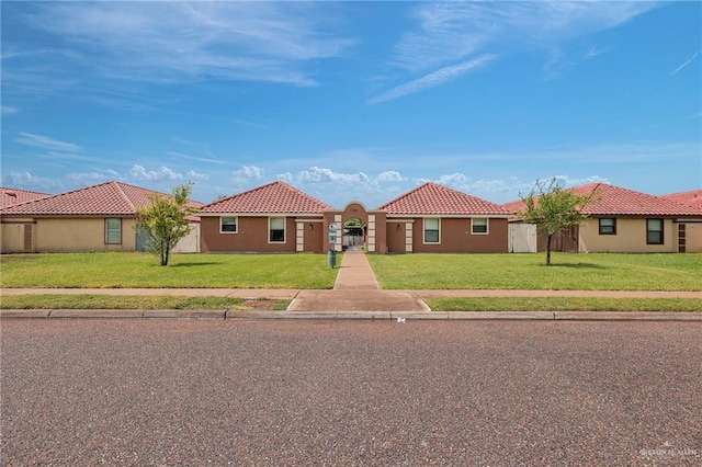303 S Ridge Ln, San Juan, TX 78589 - mediterranean / spanish home featuring a front yard, a tiled roof, and stucco siding