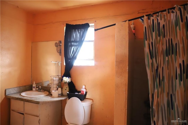 bathroom featuring toilet, a shower with shower curtain, and vanity