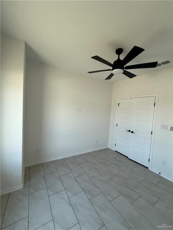 empty room featuring visible vents, baseboards, and ceiling fan