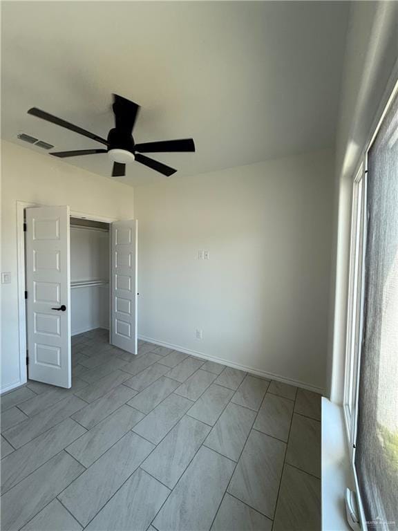 unfurnished bedroom with a closet, visible vents, baseboards, and ceiling fan