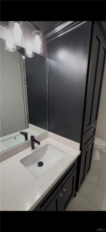 bathroom featuring vanity, tile patterned floors, and toilet