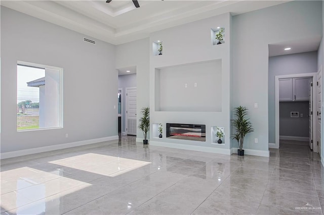 8043 N 50th St, Mcallen, TX 78504 - unfurnished living room with baseboards, visible vents, marble finish floor, and a towering ceiling