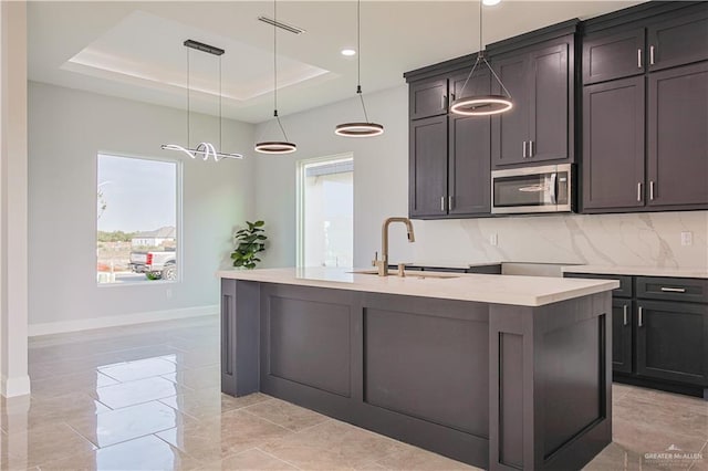8043 N 50th St, Mcallen, TX 78504 - kitchen with baseboards, stainless steel microwave, a sink, and a tray ceiling