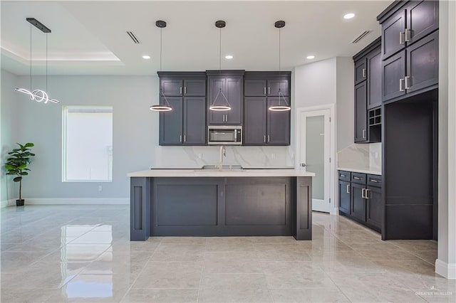 8043 N 50th St, Mcallen, TX 78504 - kitchen featuring decorative backsplash, baseboards, light countertops, stainless steel microwave, and a sink
