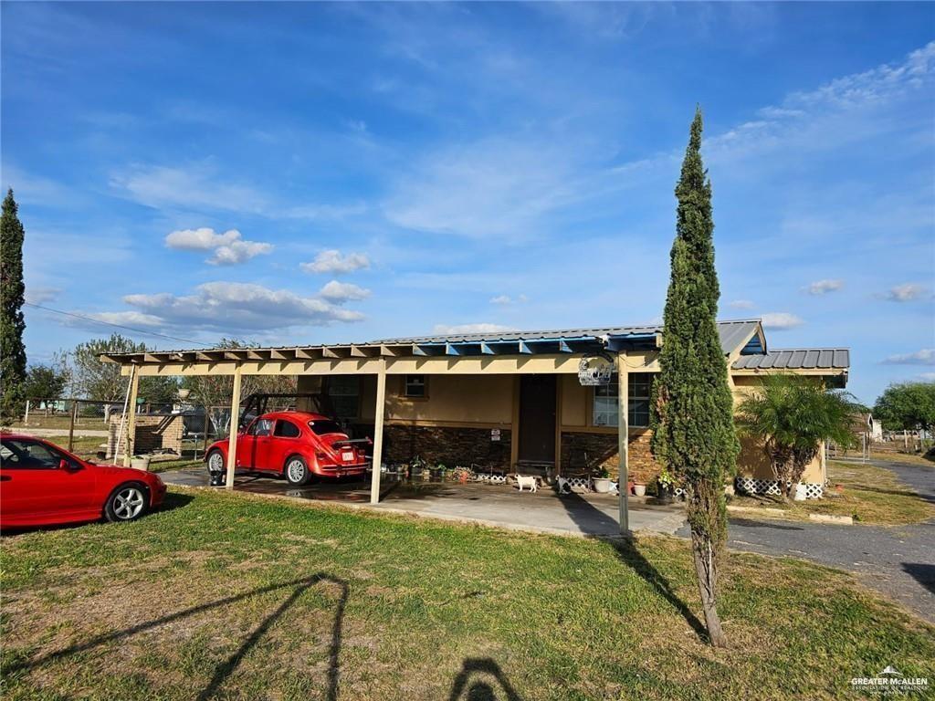 view of parking / parking lot with a carport and a yard