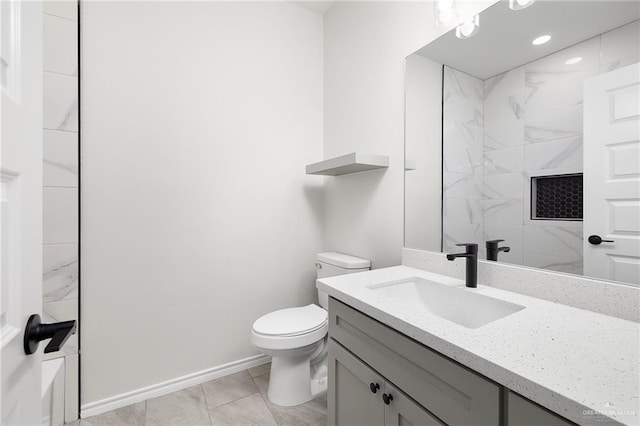 bathroom featuring vanity, toilet, baseboards, and walk in shower