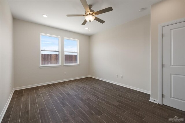 unfurnished room featuring dark wood finished floors, baseboards, and ceiling fan