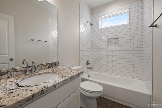 bathroom with wood finished floors, bathing tub / shower combination, vanity, and toilet