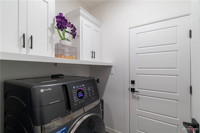 washroom featuring washer / dryer and cabinets