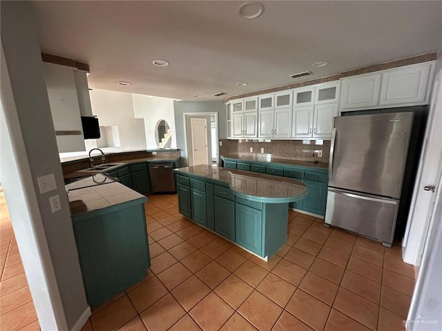 kitchen featuring sink, white cabinetry, stainless steel appliances, tasteful backsplash, and kitchen peninsula