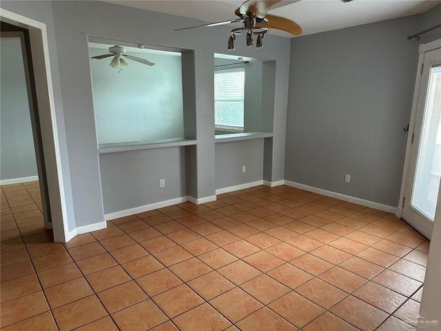 tiled spare room with ceiling fan