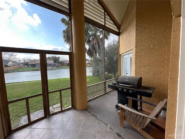 sunroom with a water view and vaulted ceiling