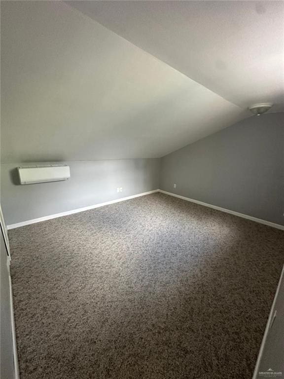 bonus room featuring dark colored carpet, vaulted ceiling, and a wall mounted AC