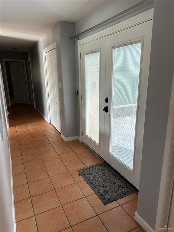 entryway with light tile patterned floors and french doors