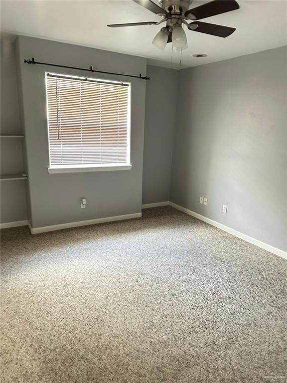 empty room featuring ceiling fan and carpet flooring