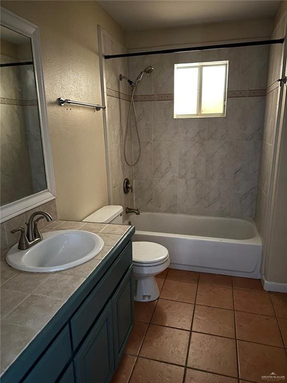 full bathroom with tiled shower / bath combo, vanity, tile patterned floors, and toilet