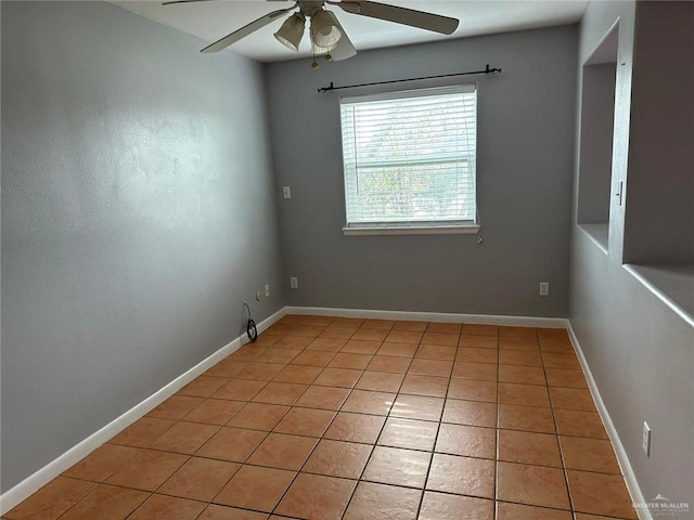 spare room with ceiling fan and light tile patterned floors