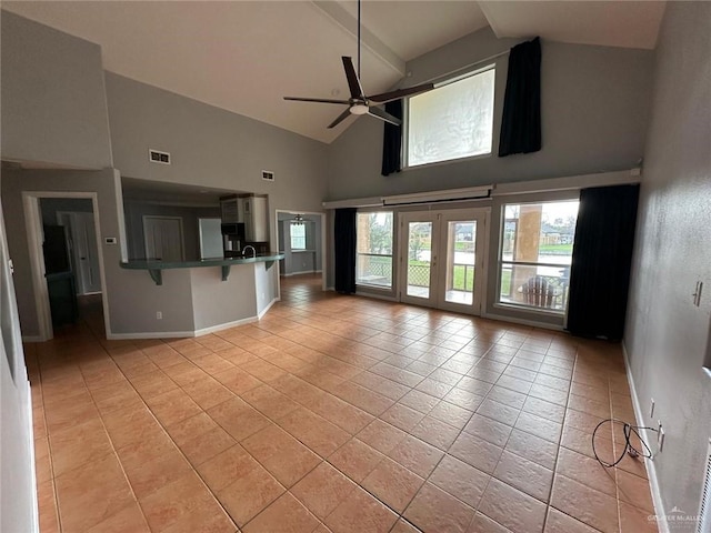 unfurnished living room with high vaulted ceiling, light tile patterned floors, and ceiling fan