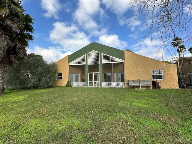 rear view of property featuring a lawn