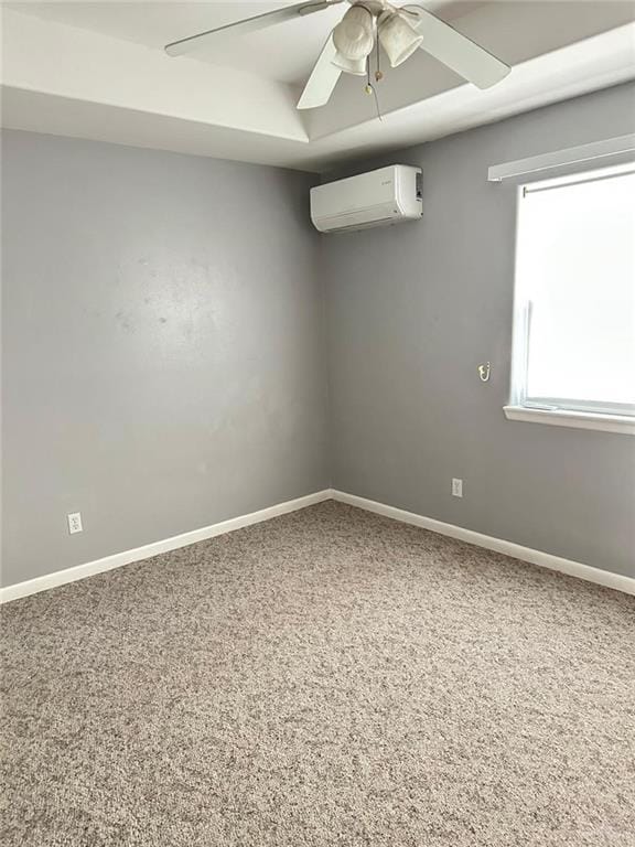 spare room with carpet floors, a wall mounted air conditioner, and ceiling fan