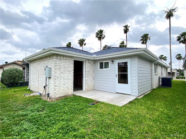 2508 Starling Cir W, Palmview, TX 78572 - back of house with brick siding, a lawn, a patio, and central AC unit