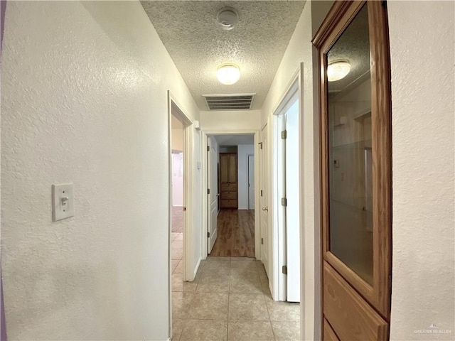 2508 Starling Cir W, Palmview, TX 78572 - hallway featuring a textured wall, a textured ceiling, visible vents, and light tile patterned floors