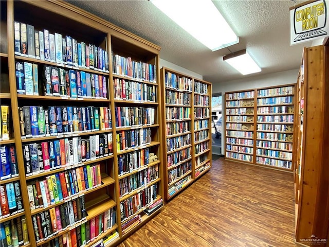 2508 Starling Cir W, Palmview, TX 78572 - living area featuring wall of books, wood finished floors, and a textured ceiling