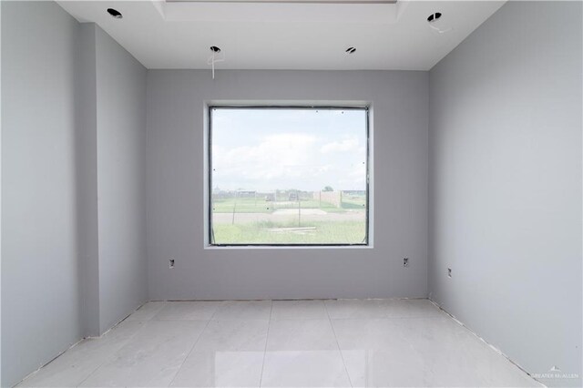 tiled spare room featuring a healthy amount of sunlight