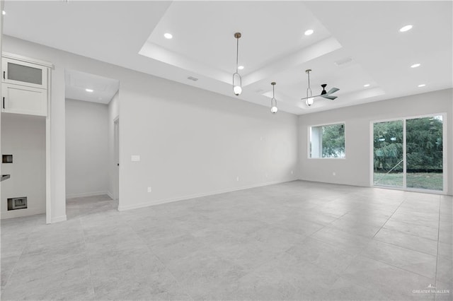 empty room with a tray ceiling, ceiling fan, baseboards, and recessed lighting