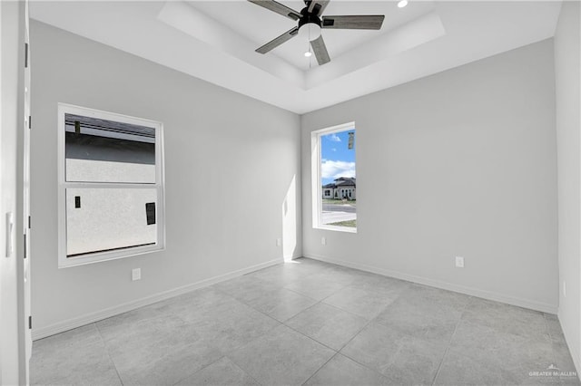 empty room featuring a tray ceiling, baseboards, ceiling fan, and recessed lighting