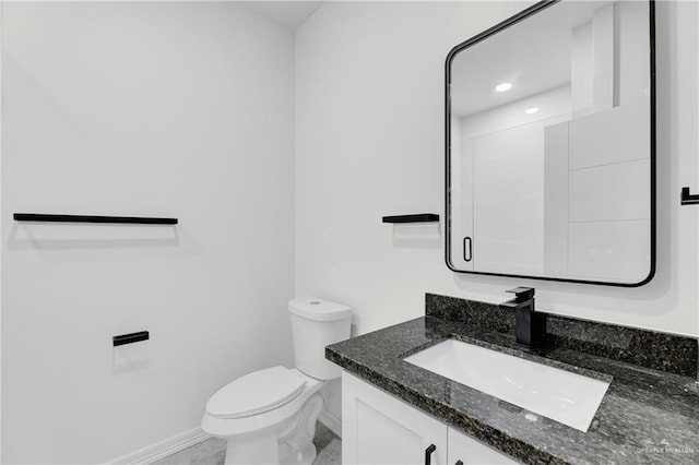 bathroom with baseboards, recessed lighting, vanity, and toilet