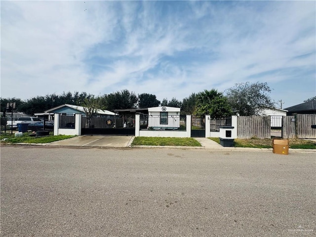 view of front facade with a carport, a fenced front yard, and a gate