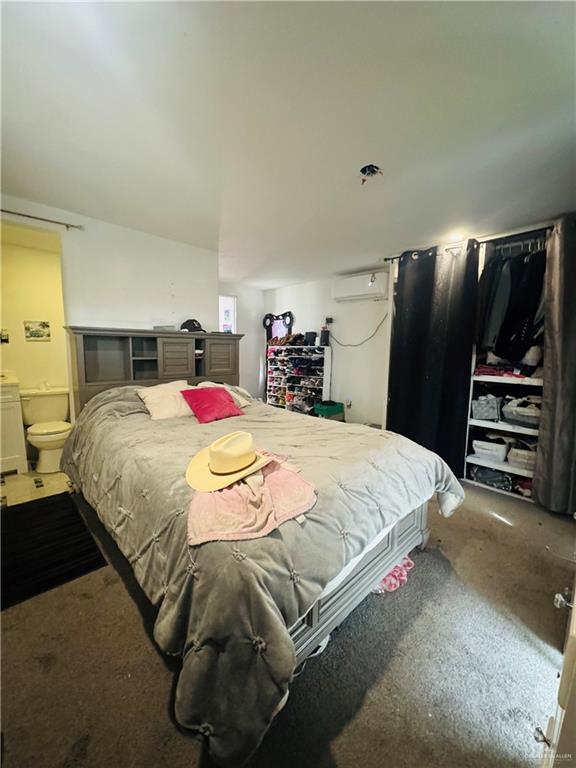 bedroom with a wall unit AC and ensuite bath