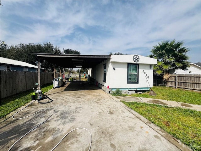 manufactured / mobile home with a carport, driveway, a front lawn, and fence