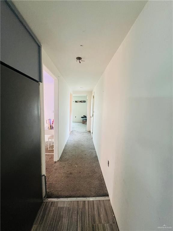 hallway with carpet and wood finished floors