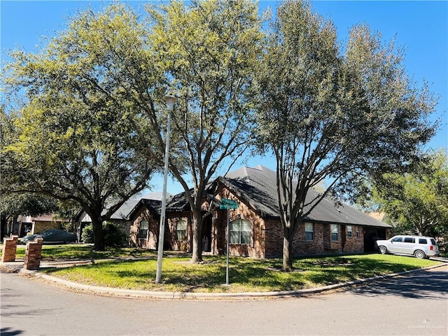 ranch-style home with brick siding and a front yard