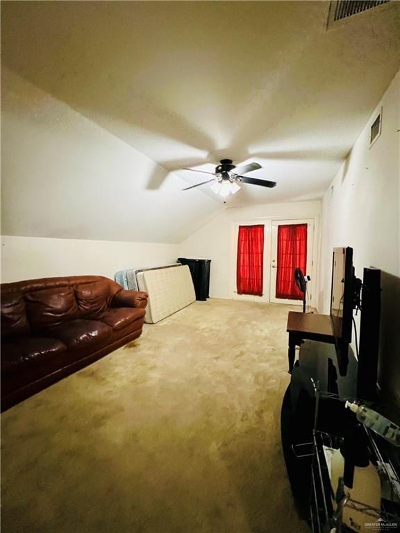 carpeted living room with visible vents, ceiling fan, and vaulted ceiling