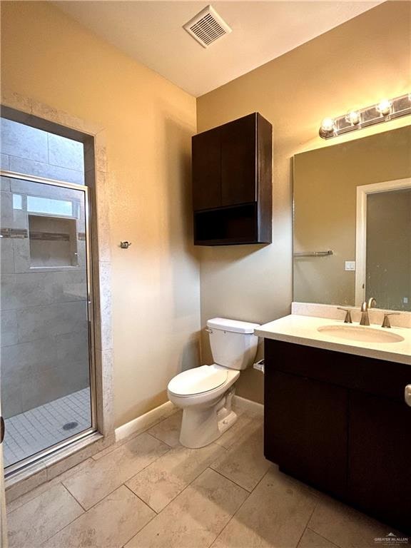 bathroom with vanity, an enclosed shower, and toilet