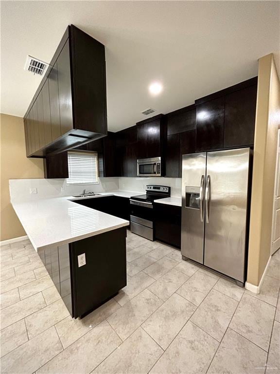 kitchen featuring kitchen peninsula, stainless steel appliances, and sink