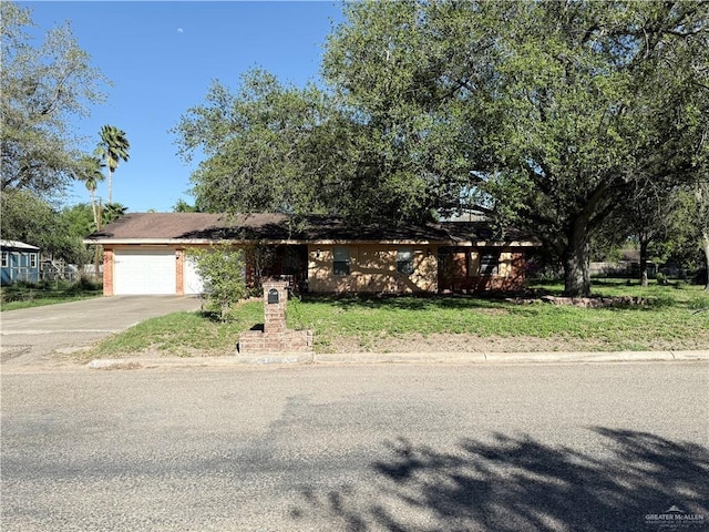 view of front of property featuring a front yard, driveway, and an attached garage