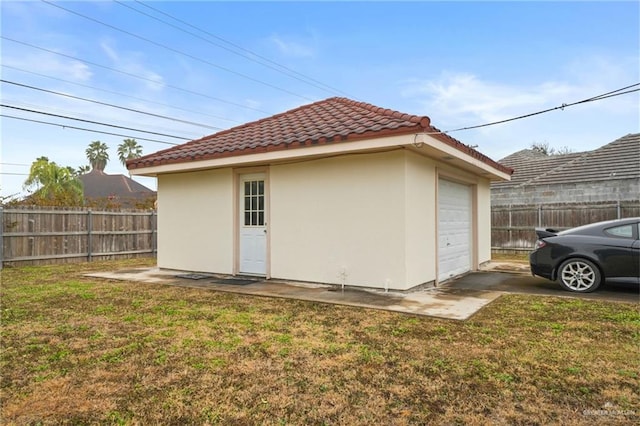 view of home's exterior featuring a garage, an outdoor structure, and a lawn