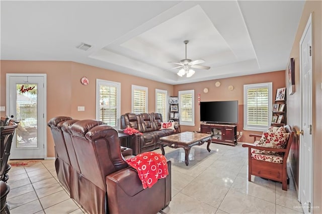 tiled living room featuring a tray ceiling and ceiling fan