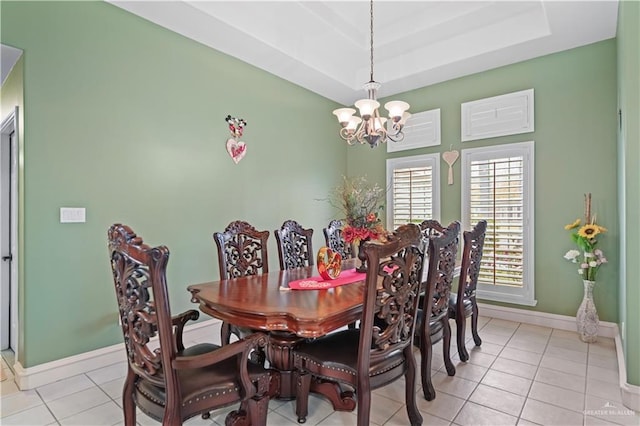 tiled dining room with a raised ceiling and a notable chandelier