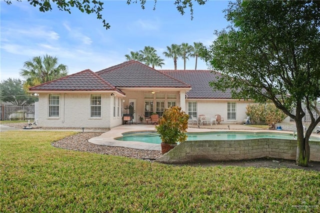 back of house featuring a fenced in pool, a patio area, and a lawn