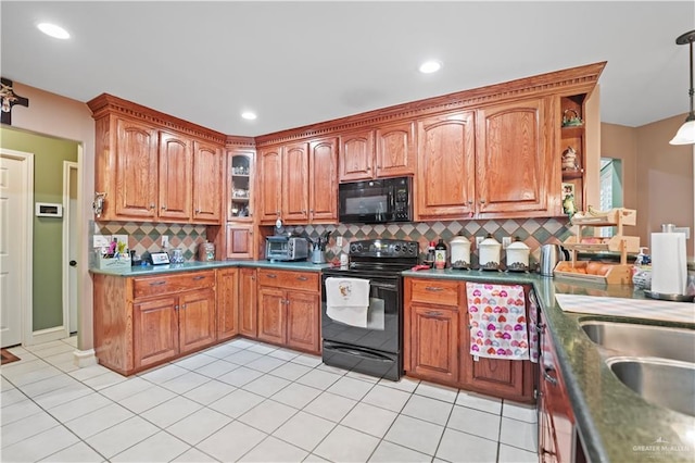 kitchen with sink, black appliances, hanging light fixtures, light tile patterned floors, and backsplash