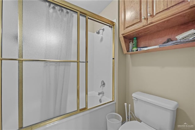 bathroom featuring enclosed tub / shower combo and toilet