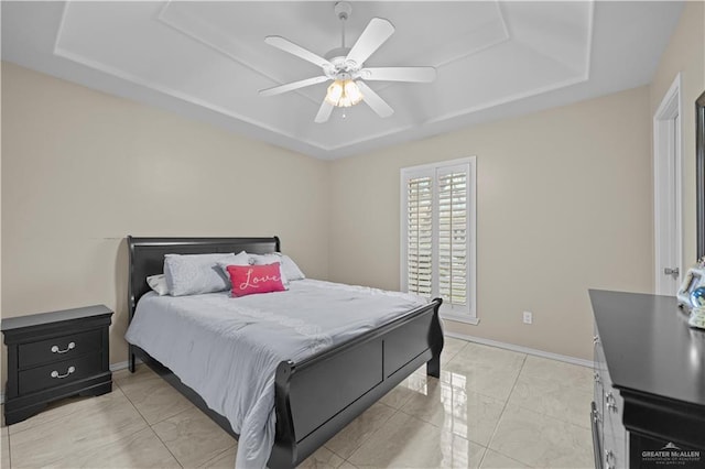 bedroom featuring a raised ceiling and ceiling fan