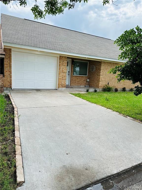 1523 Evergreen Ave, Mission, TX 78572 - ranch-style house with brick siding, an attached garage, concrete driveway, and roof with shingles